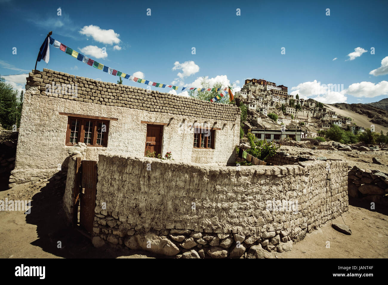 Tibetischen Stil Haus im Dorf, direkt unterhalb der buddhistischen Thiske Gompa mit tibetisch-buddhistische Gebetsfahnen flattern im Wind sitzt Stockfoto