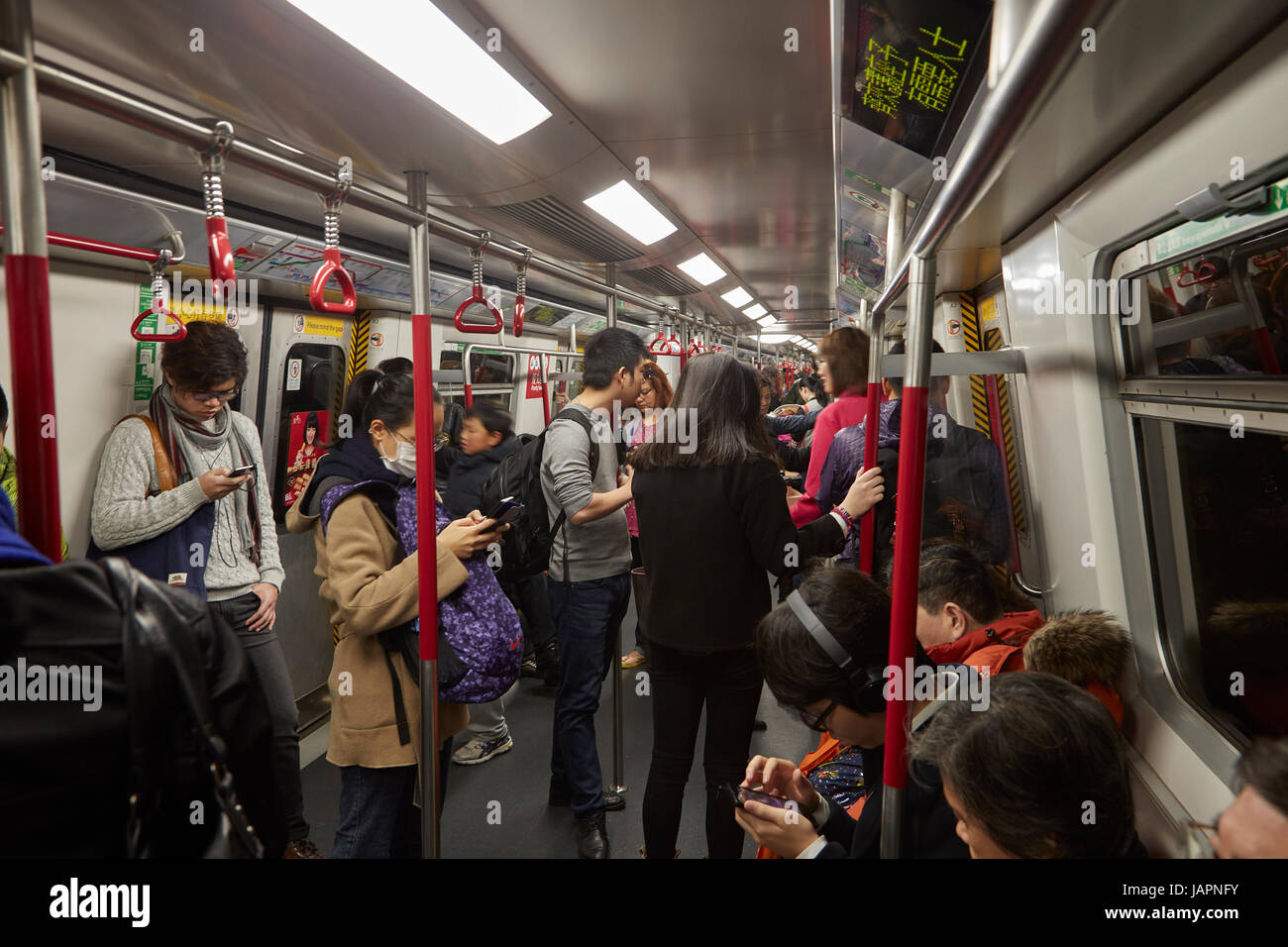 Passagiere auf ihren Smartphones auf MTR u-Bahn System, Hong Kong, China Stockfoto