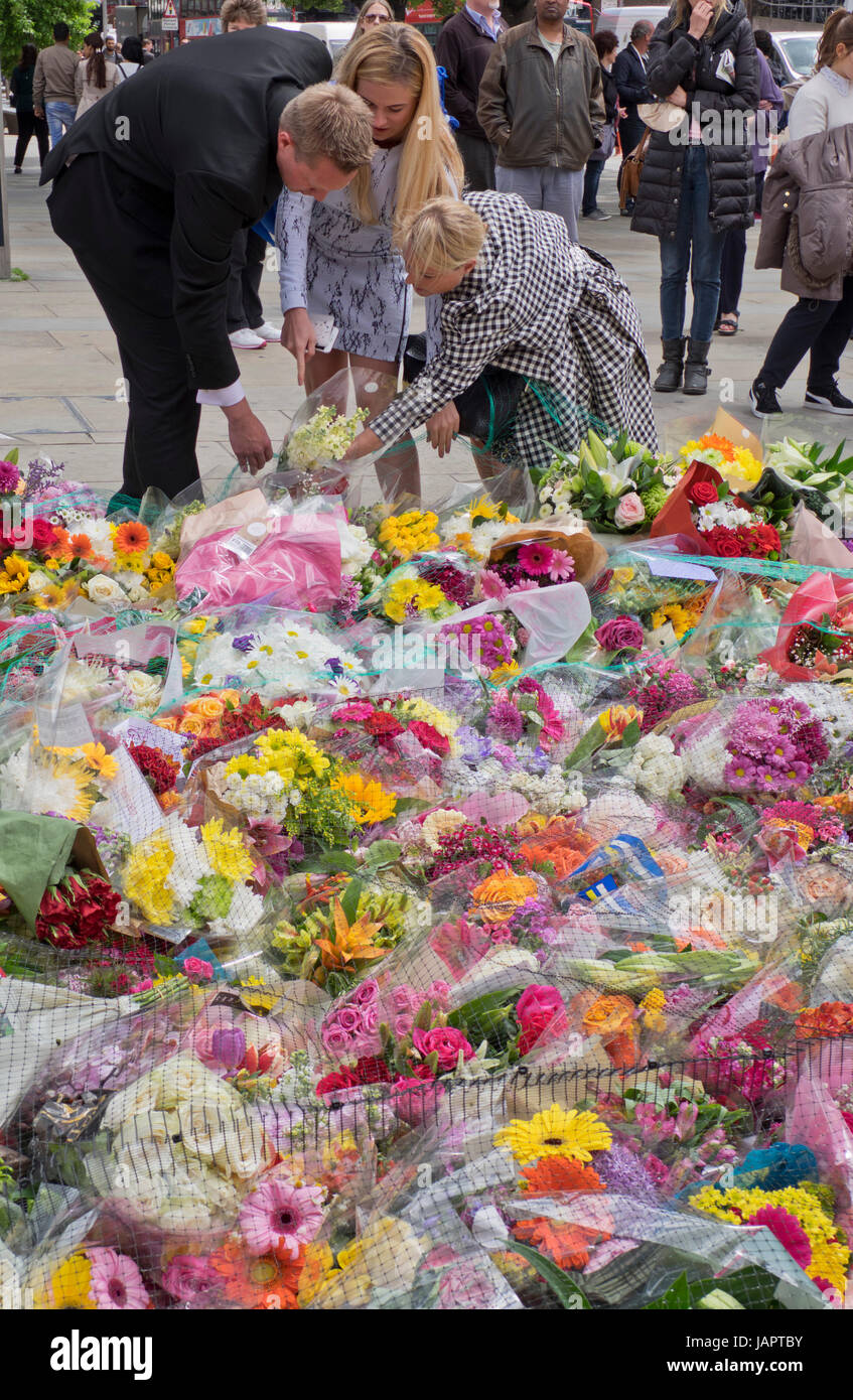 Menschen legen Blumen Angebote auf dem Bürgersteig von London Bridge, wo Menschen wurden getötet und verwundet in einem terroristischen Anschlag in der Nacht vom 3. Juni 2017.London,UK Stockfoto