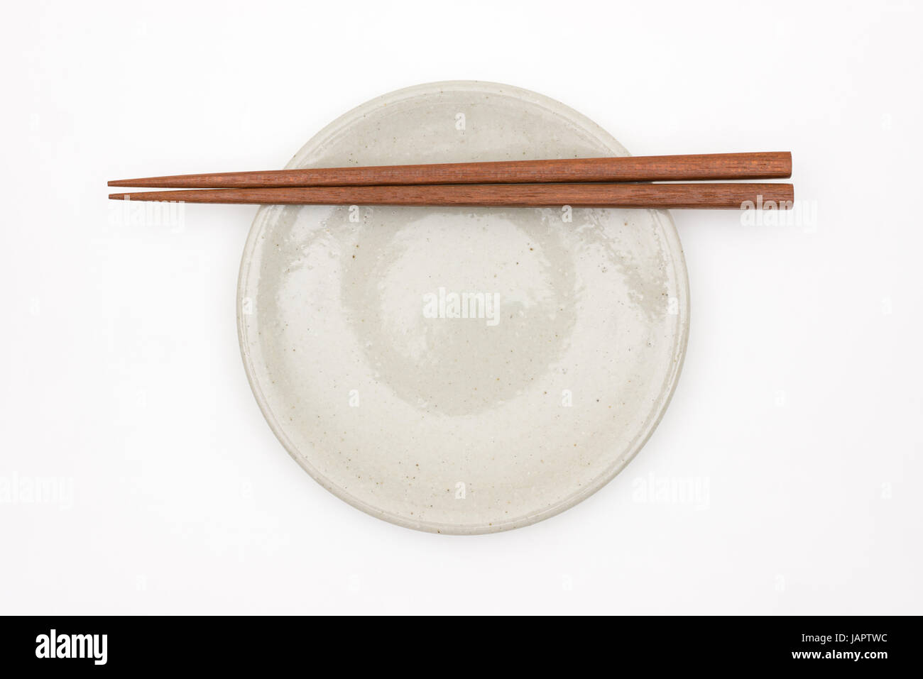 Traditionelle japanische hölzerne Essstäbchen auf weißen Keramikplatte Stockfoto