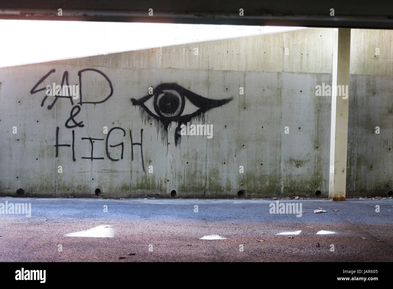 TROY, NEW YORK, 25. Februar 2017: Graffiti an der Wand eines Parkplatzes "Sad und High" kann Ausdruck der Opiatabhängigkeit fegen USA sein. Stockfoto