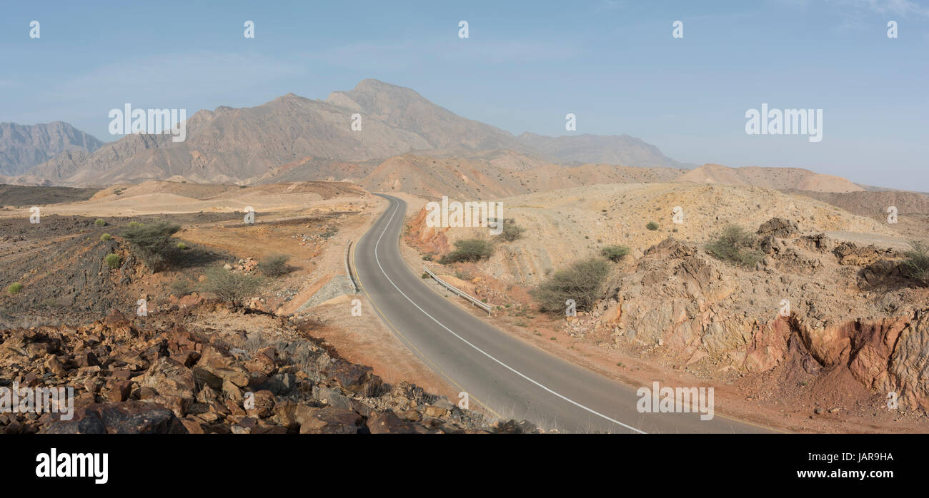 Eine Straße, die durch den einsamen Bergen des Sultanats von Oman Stockfoto