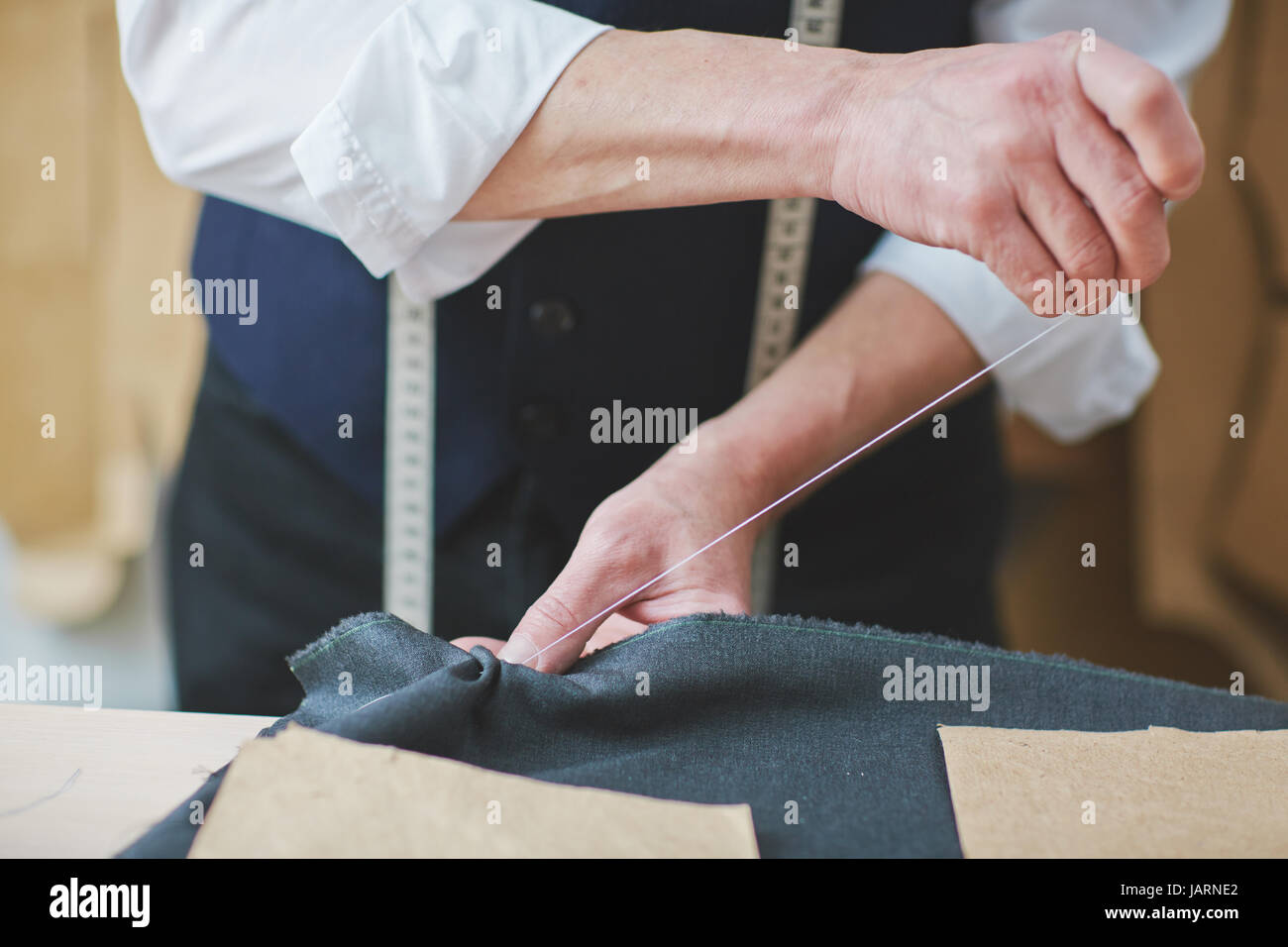 Schneider Hand nähen Stoff im Atelier Stockfoto