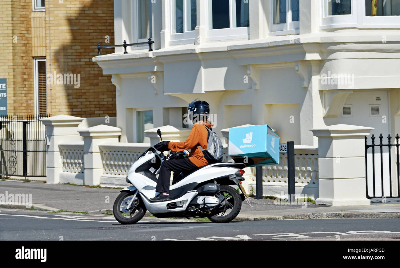 Deliveroo Fastfood Lieferung Fahrer auf einem Roller Foto von Simon Dack Stockfoto