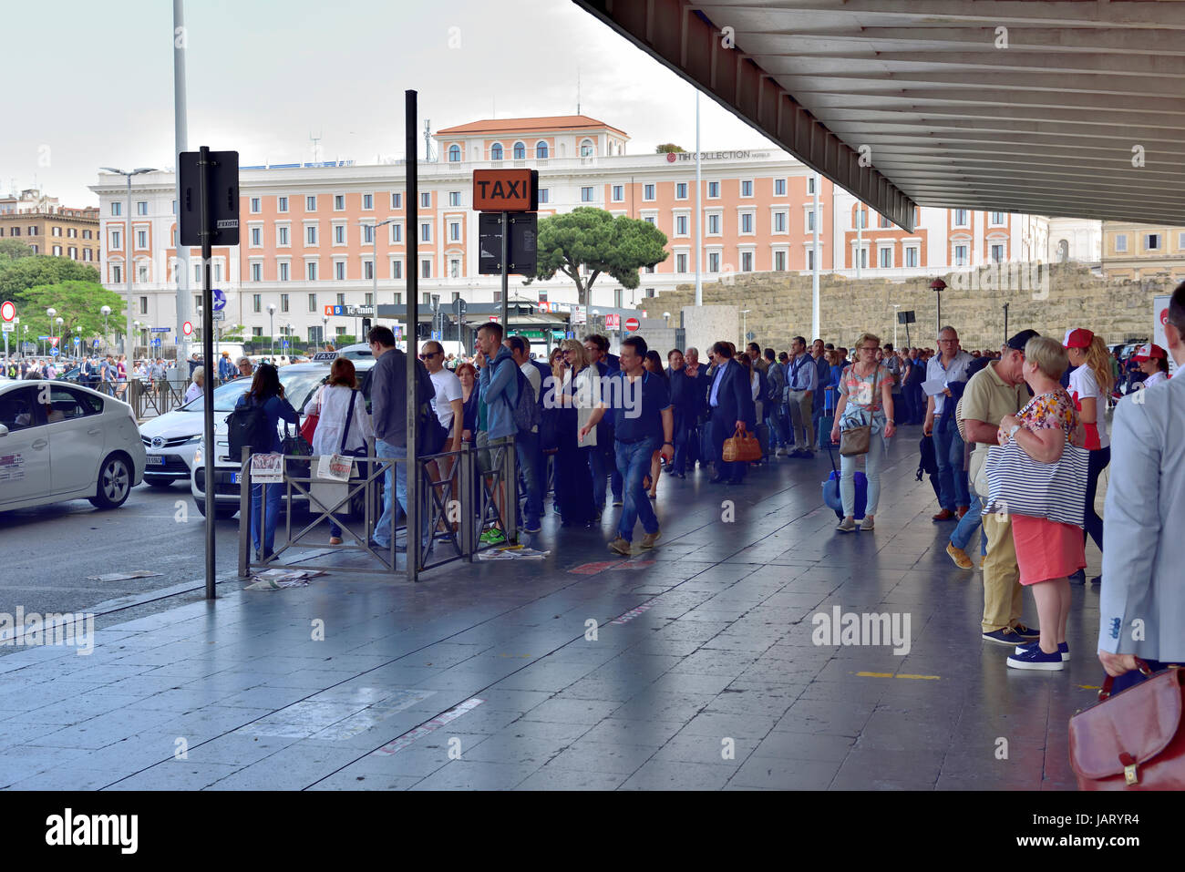 Lange Schlange von wartenden Menschen stehen für Taxis vor Roma Termini (Stazione Termini) Roms wichtigste ÖPNV Anschluß Stockfoto