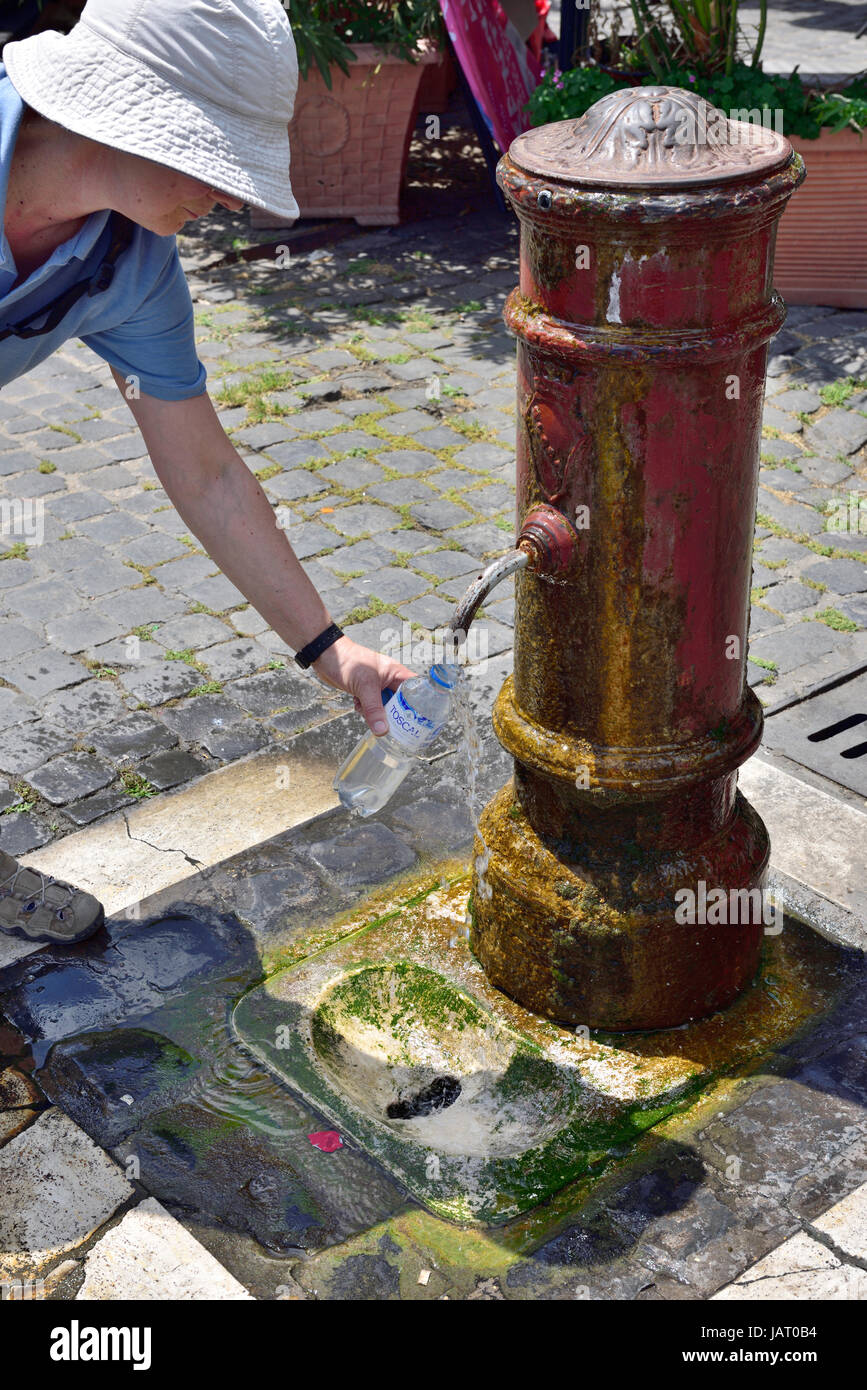 Frau Füllung Wasserflasche an öffentliche Trinkbrunnen (Fontanelle Zapfen) in Rom Stockfoto