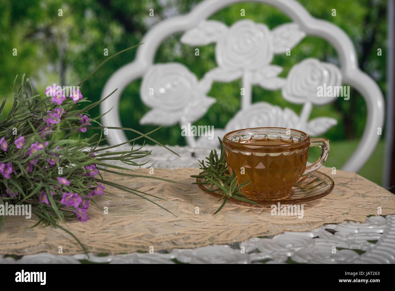 Tasse Kaffee sitzen auf einem weißen Tisch im Freien mit einem Blumenstrauß Stockfoto