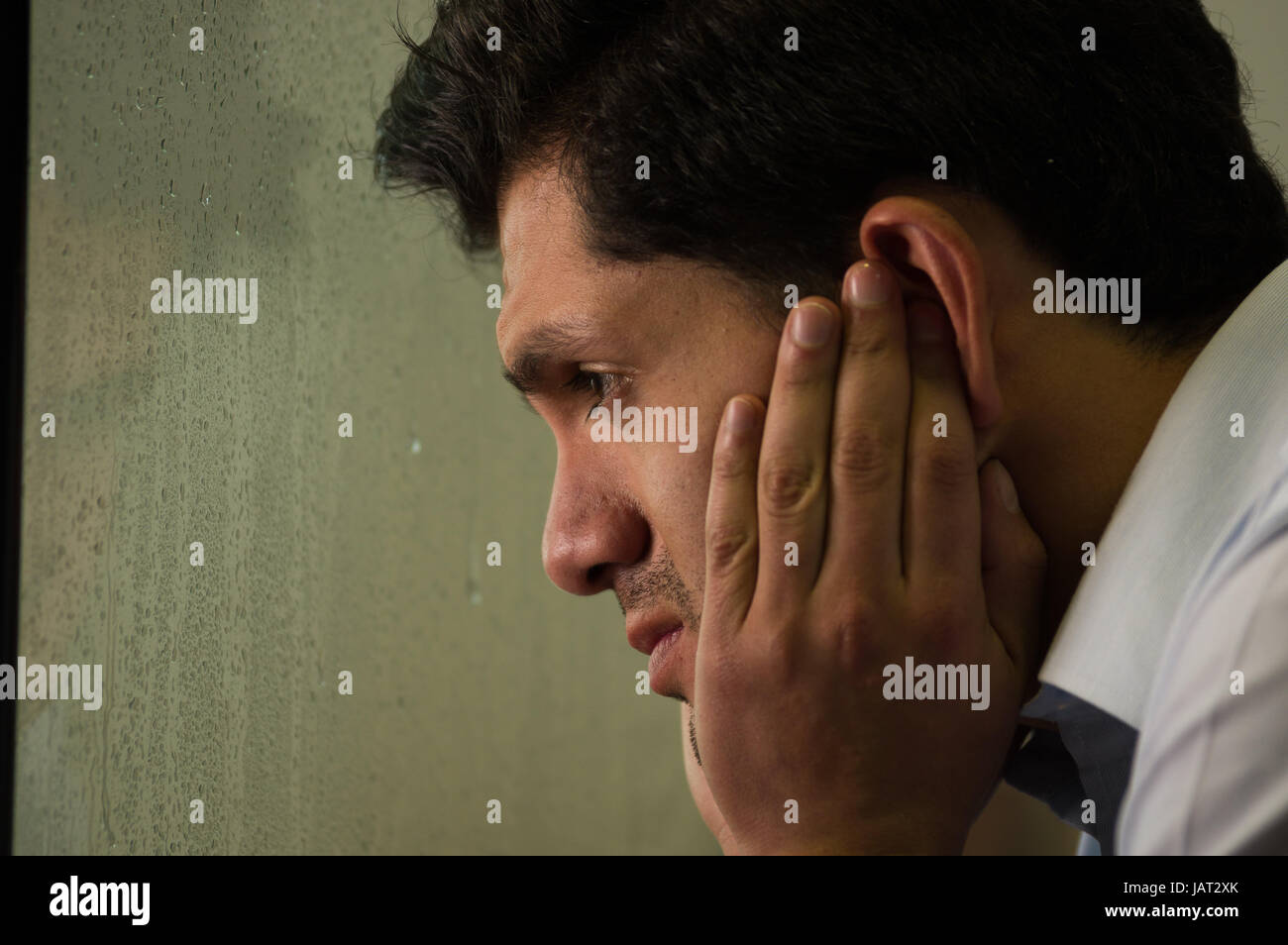 Besorgter gespiegelter junge Mann ist Depresed, grauen Hintergrund. Stockfoto