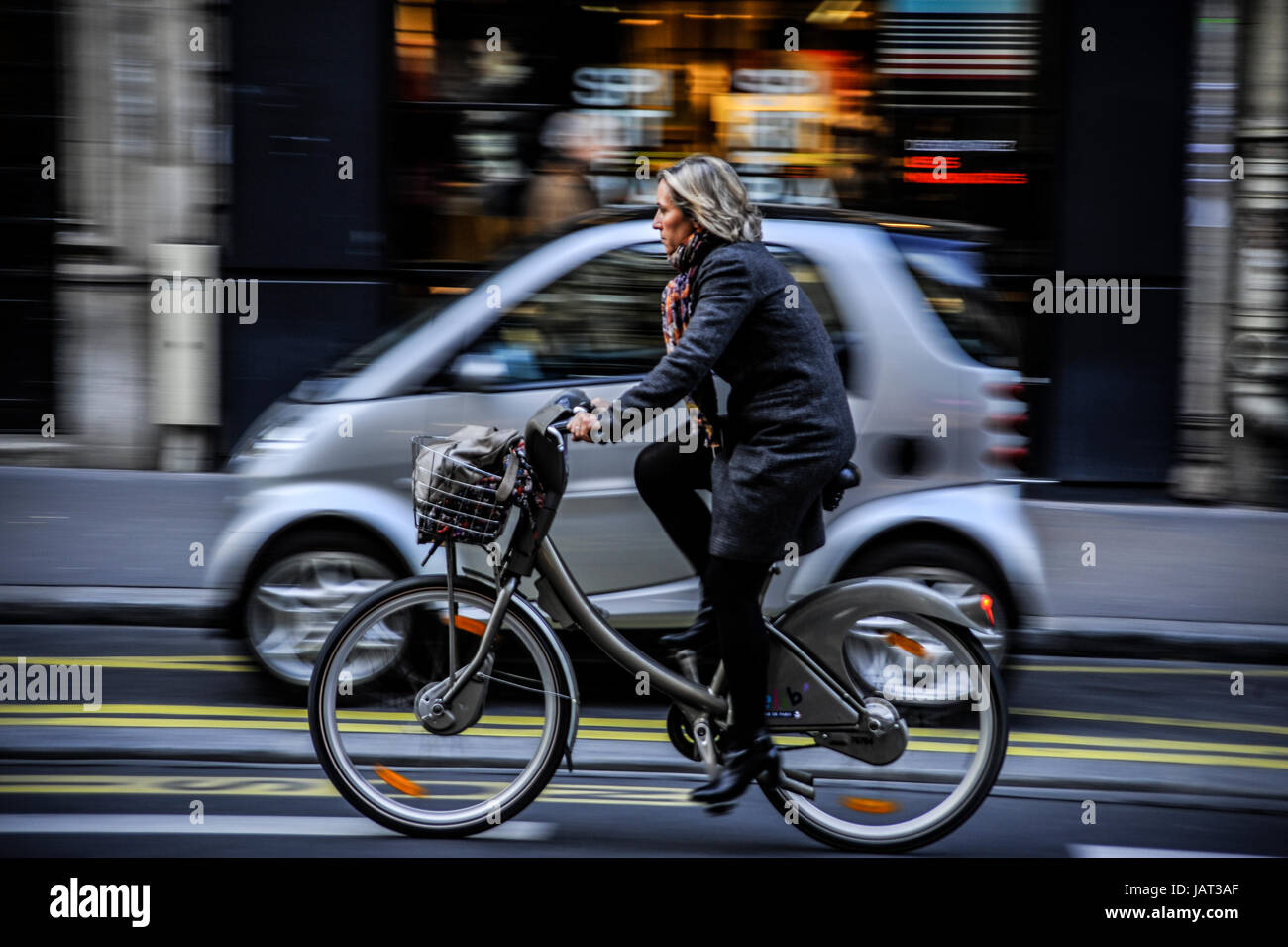 PARIS FRAU AUF DEM FAHRRAD IN DER RUE DE RENNES - PARIS VELIB - PARIS FRAU AUF DER STRASSE - PARIS URBAN LIFE © FRÉDÉRIC BEAUMONT Stockfoto