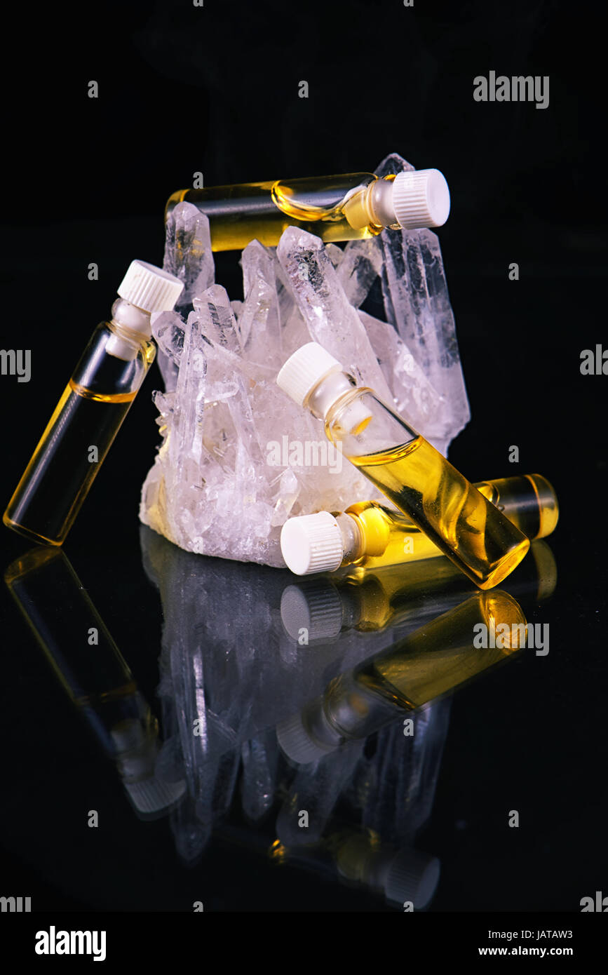 Detail des Cannabis Ölbehälter und Bergkristall isoliert auf schwarz - medizinisches Marihuana-Konzept Stockfoto