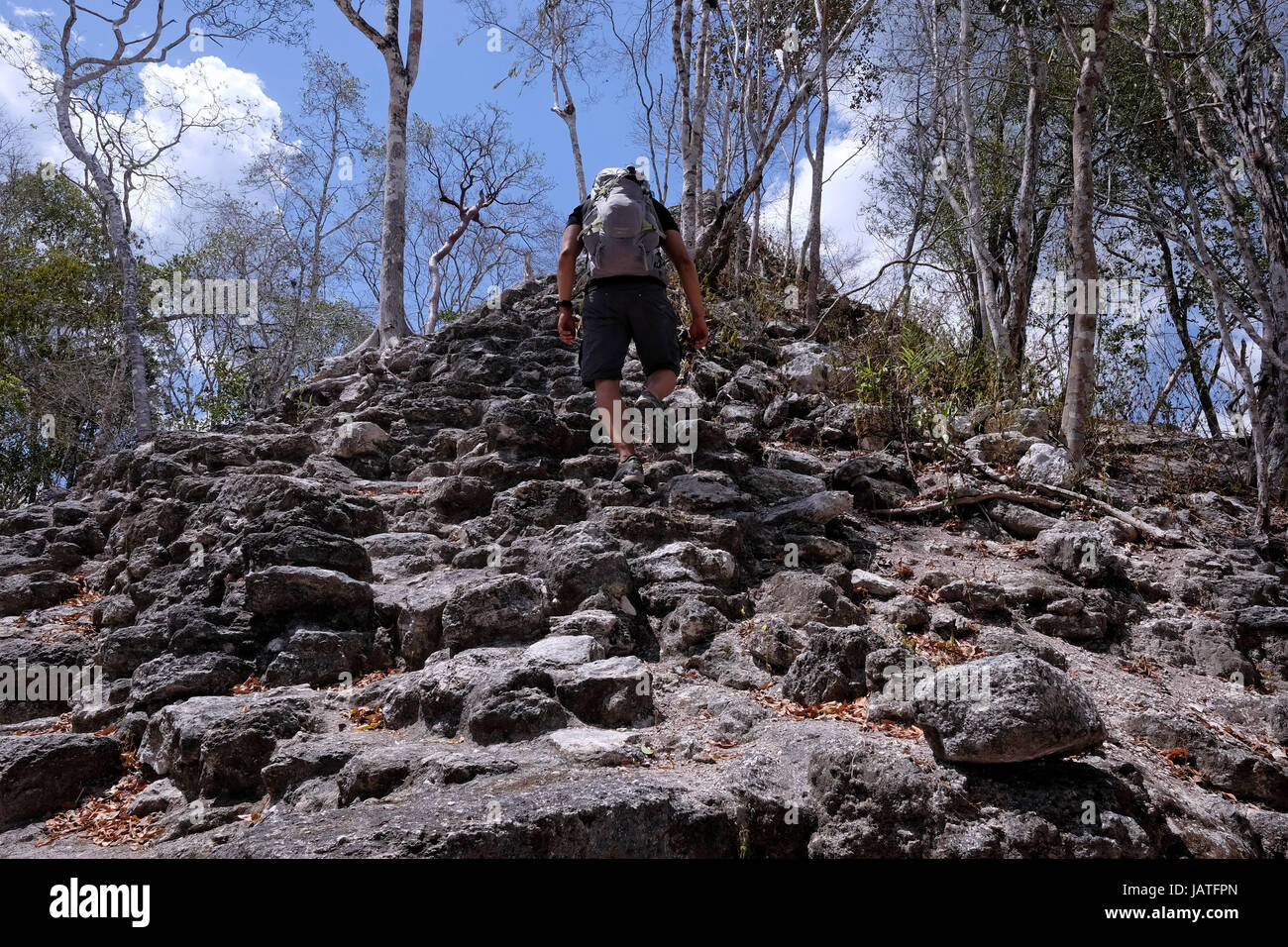 Ein Wanderer eine kleine Pyramiden-Struktur auf der Seite der Hauptpyramide auf der obersten Plattform klettern den Spitznamen El Tigre, bildet das übliche triadische Muster am El Mirador einer großen präkolumbischen Maya-Siedlung, befindet sich in einem abgelegenen Ort tief im Dschungel im Norden der modernen Abteilung der El Petén, Guatemala Stockfoto