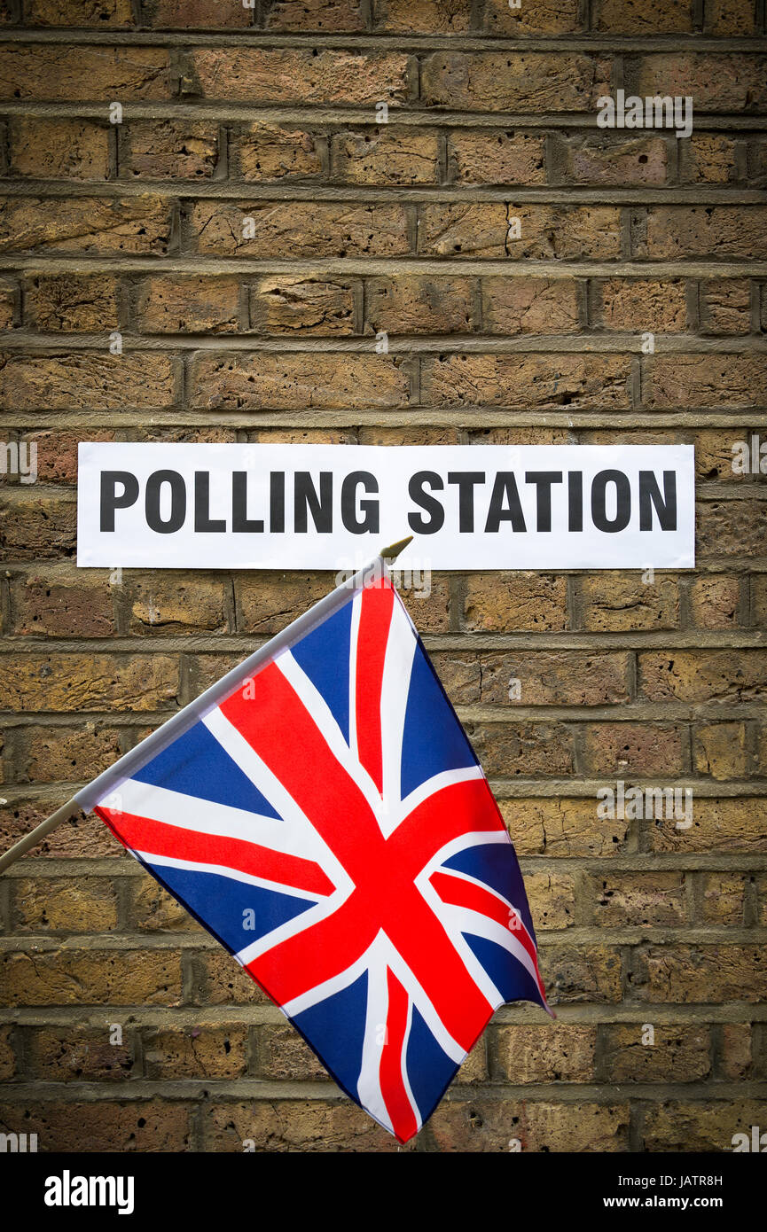 Union Jack-Flagge hängt vor Wahlen in Großbritannien Wahllokal ausgeschildert auf klassischen gelben Ziegelwand in London, Großbritannien Stockfoto
