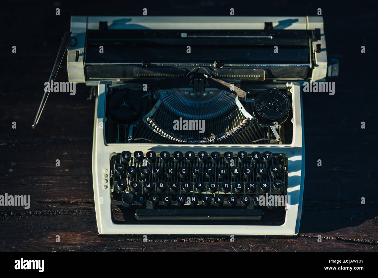Foto der alten Schreibmaschine auf Holztisch im Sonnenuntergang Licht, Retro-Look. Stockfoto