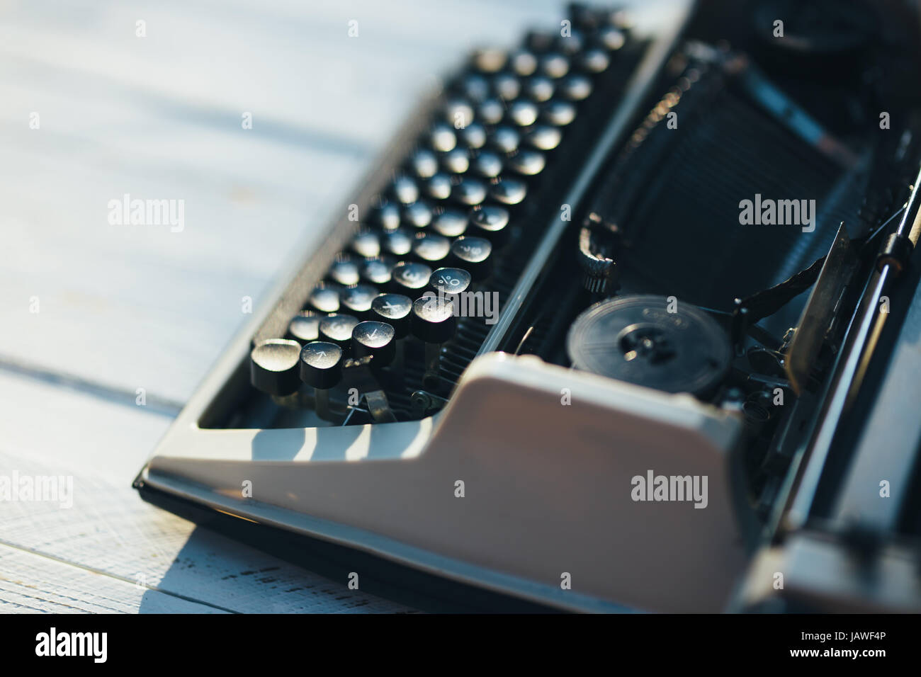 Foto der alten Schreibmaschine auf Holztisch im Sonnenuntergang Licht, Retro-Look. Stockfoto