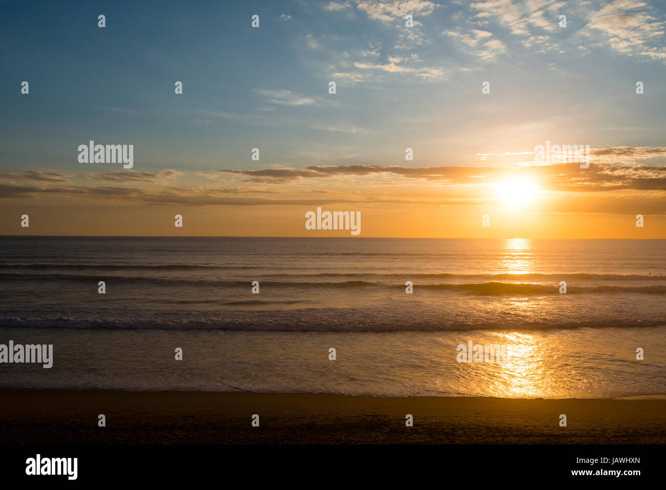 Sonnenuntergang steigt auf einem breiten Strand im Sommer. Stockfoto