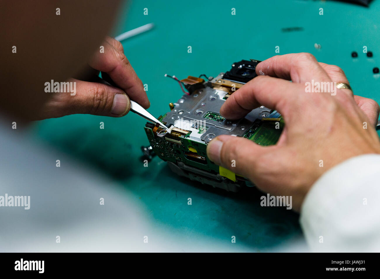 Ein Kamera-Techniker repariert Sensor, Leiterplatte und CPU einer Digitalkamera. Stockfoto