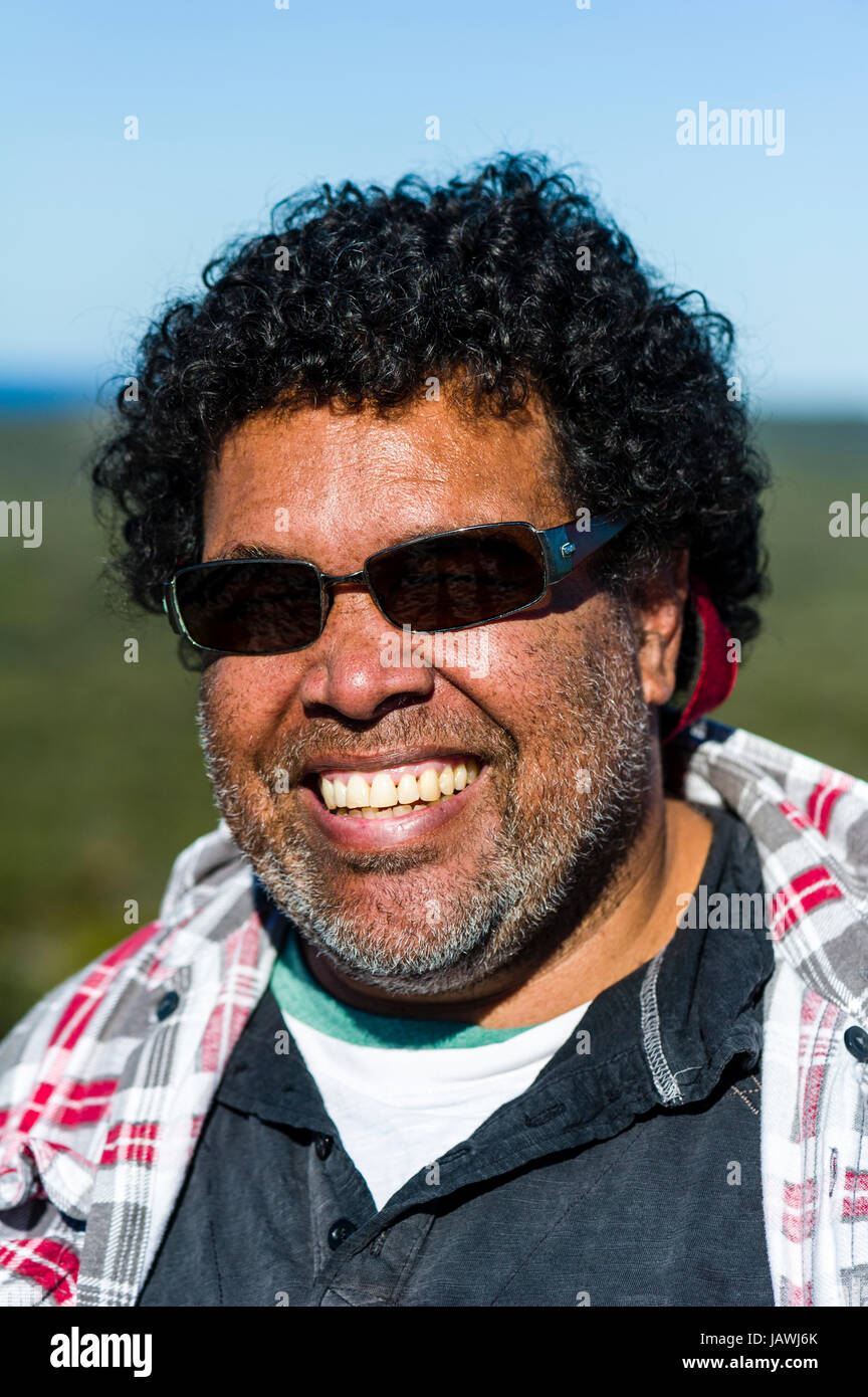 Ein lächelnder Aborigines Mann mit Sonnenbrille an einem sonnigen Tag. Stockfoto