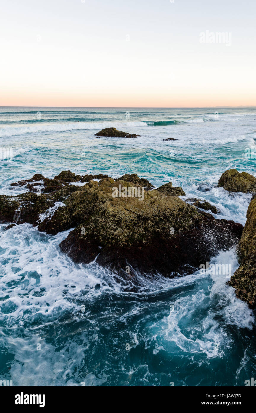 Wellen zerschlagen gegen schroffe Felsen auf einem unberührten Küste. Stockfoto