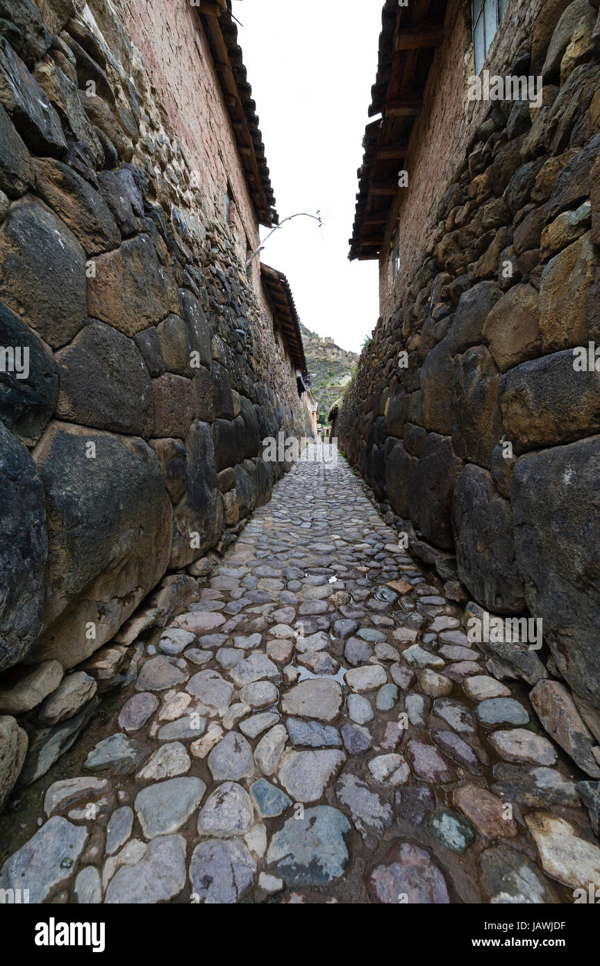 Eine Dorf-Lane mit Steinen gepflastert und gesäumt von hohen Inka Trockenmauern. Stockfoto