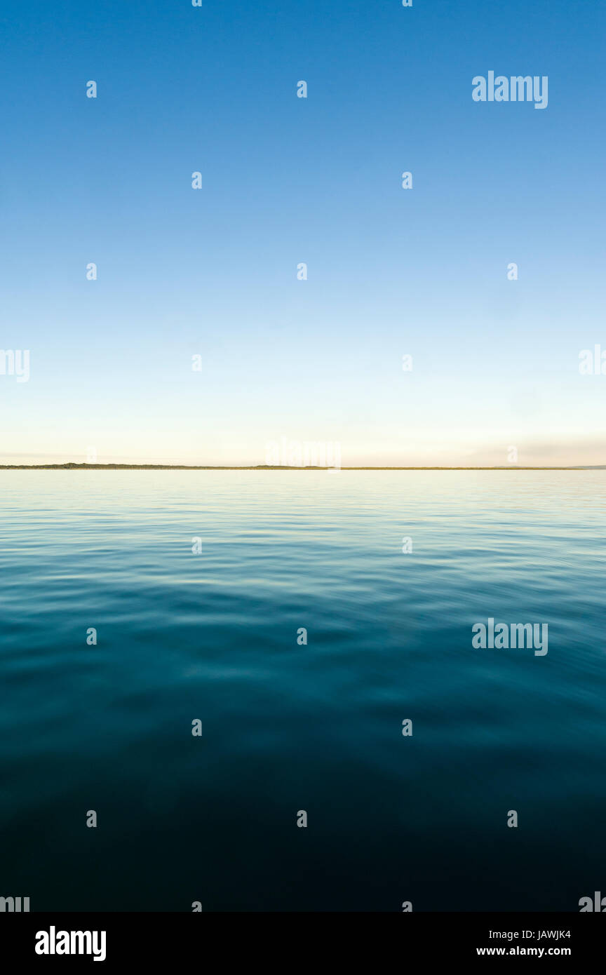 Eine Flaute Meeresoberfläche in der Dämmerung. Stockfoto Eine Flaute Meeresoberfläche in der Dämmerung. Stockfoto