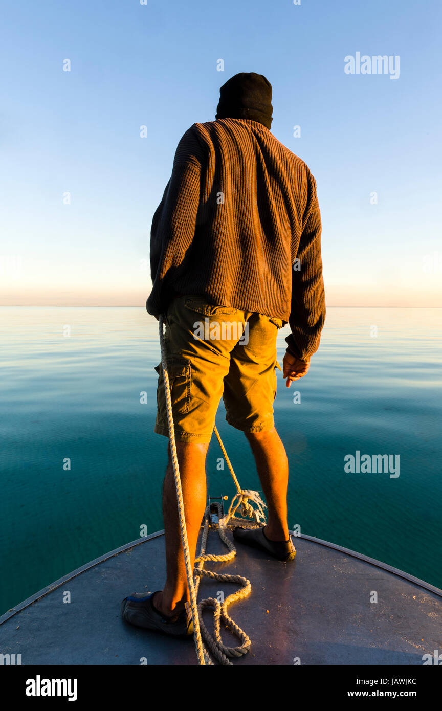 Ein Aborigine-Führer steuert ein Boot durch Sandbänke bei Niedrigwasser. Stockfoto