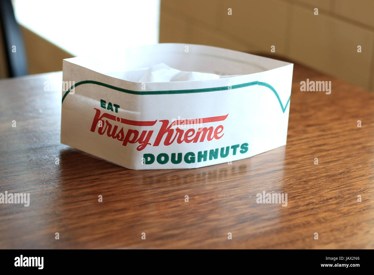 Krispy Kreme Papierhut auf Holztisch Stockfoto