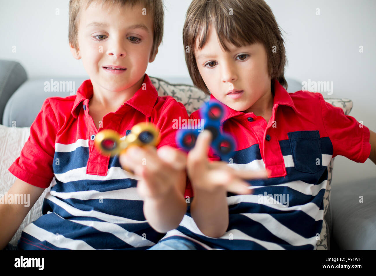 Meine lieben Kinder, junge Brüder spielen mit bunten Fidget Spinner Spielzeug um Stress zu Hause Stockfoto