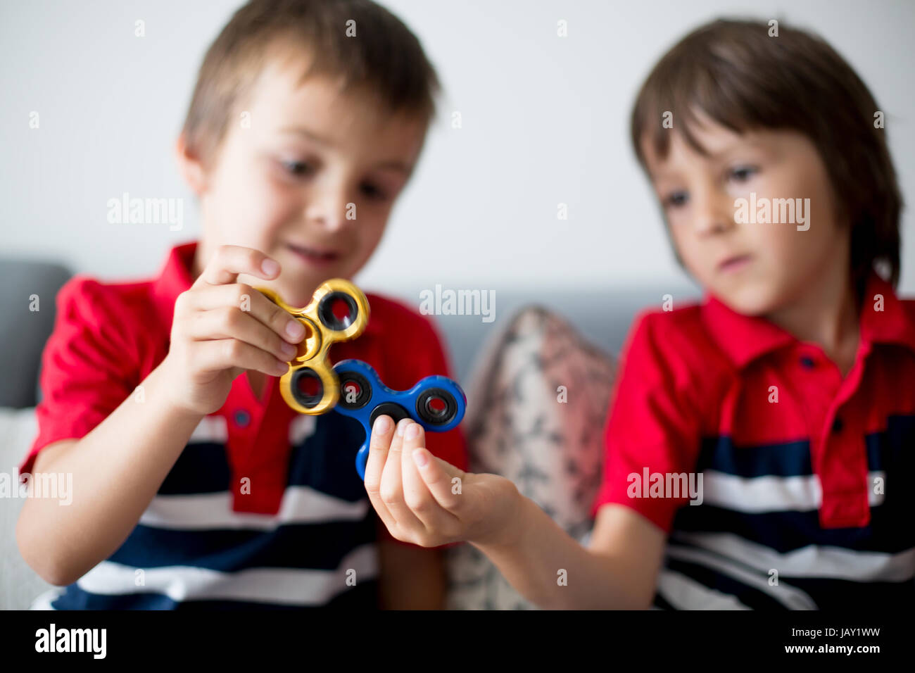 Meine lieben Kinder, junge Brüder spielen mit bunten Fidget Spinner Spielzeug um Stress zu Hause Stockfoto