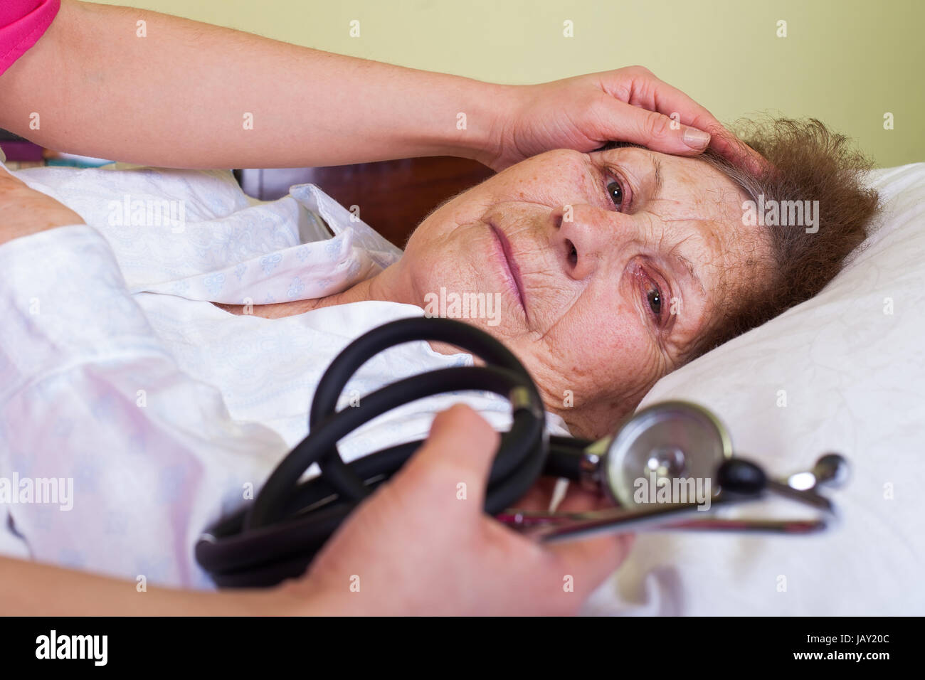 Bild von einem Bett geritten ältere Frau mit ihrem Care Holding ein Stethoskop Stockfoto