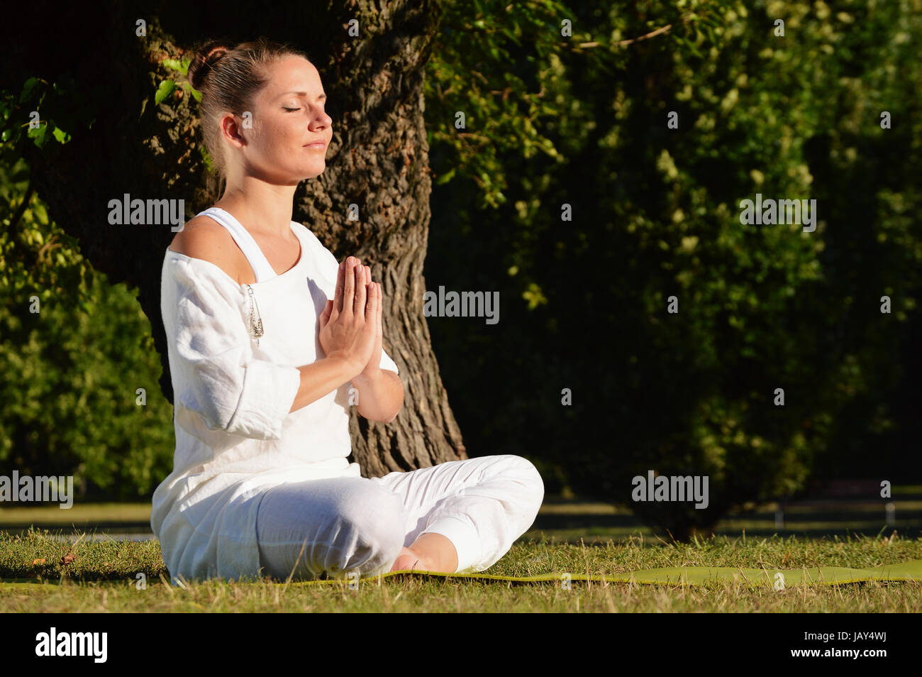 Junge Frau während der Yoga-Meditation im park Stockfoto