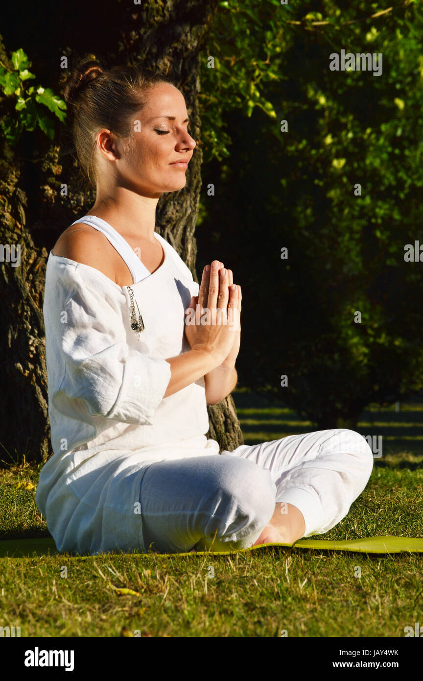 Junge Frau während der Yoga-Meditation im park Stockfoto