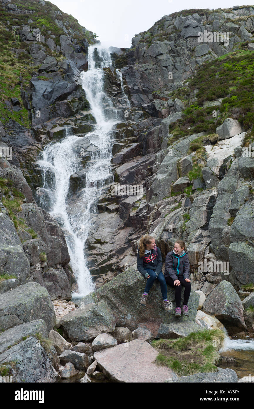 Zwei Kinder entspannende unterhalb der Wasserfälle von Glasallt in der Nähe von Schloss Muick Cairngorms Nationalpark Schottland Stockfoto