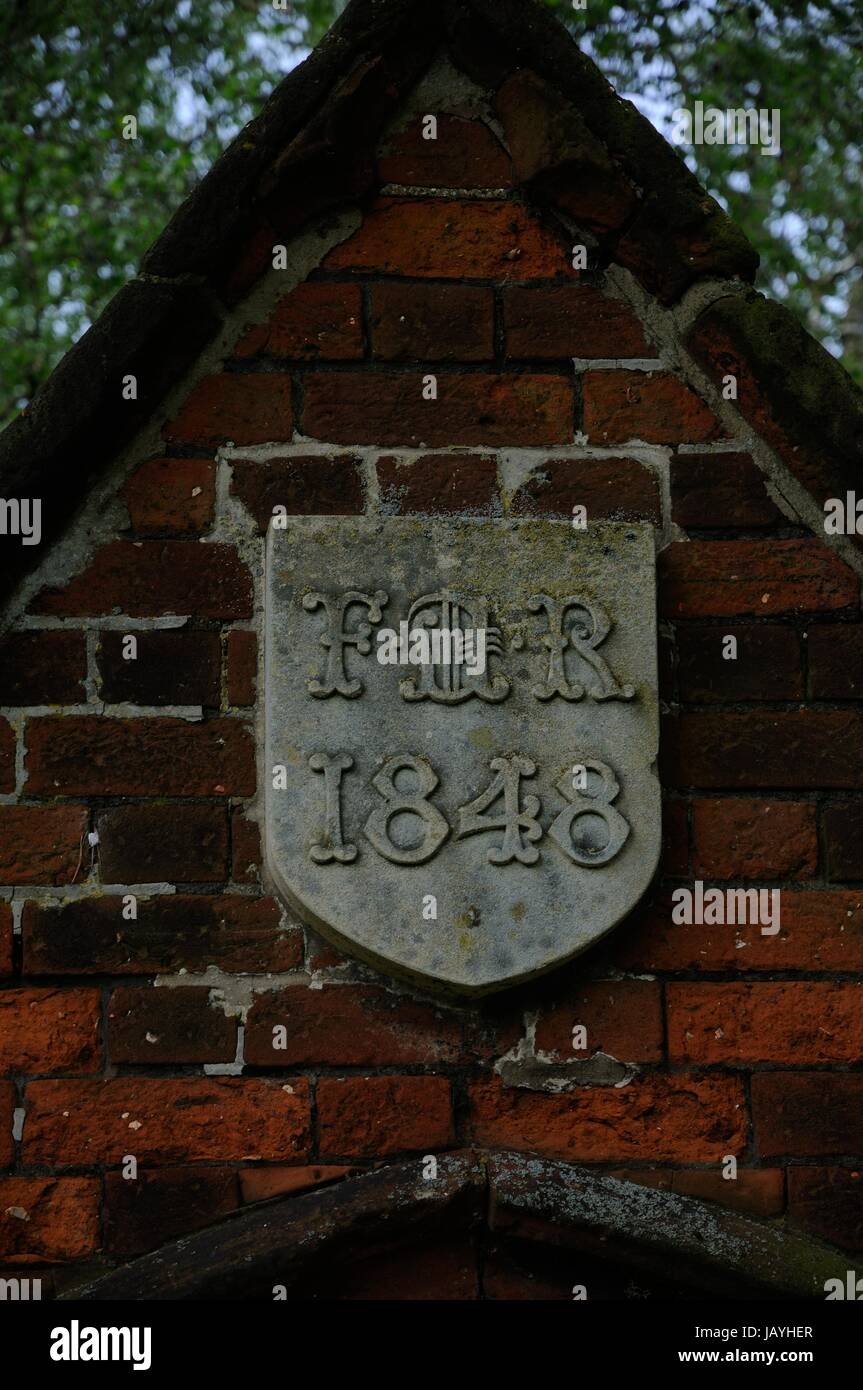 Das Gateway und die Wand zur Ickleford Schule, Ickleford, Hertfordshire stehen neben oberen grün.  Das Tor hat die Inschrift "FDR" "1848". Stockfoto