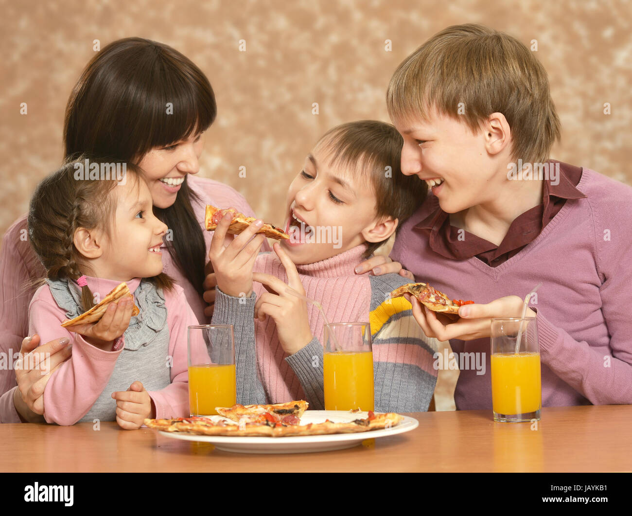 Mutter mit Kindern Pizza essen Stockfoto