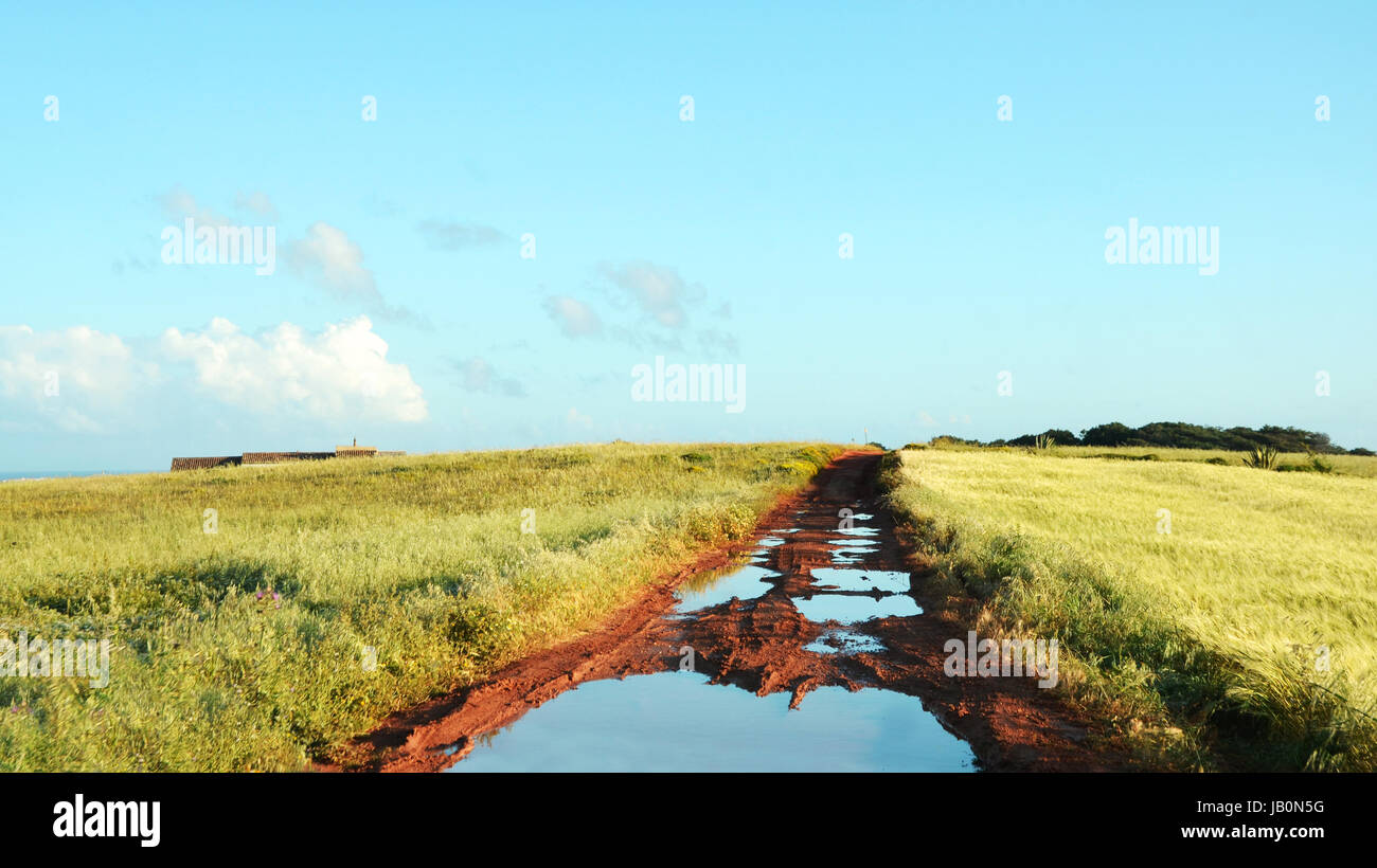 Landstraße mit Schlaglöchern nach starken Regenfällen an der Westküste der Algarve Stockfoto