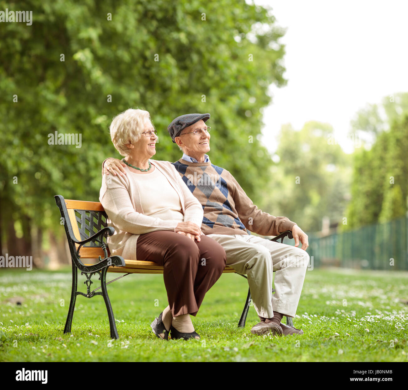 Älteres Paar auf einer Bank im Park sitzen und wegsehen Stockfoto