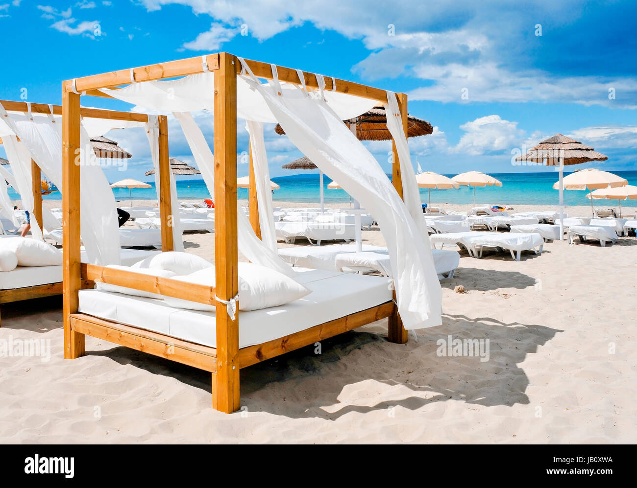 Blick auf einige Betten in einem Beach-Club in einem weißen Sandstrand in Ibiza, Spanien Stockfoto