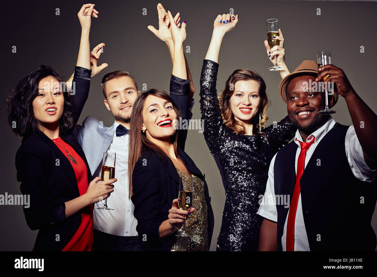Fröhliche Freunde tanzen mit Hands Up Stockfoto
