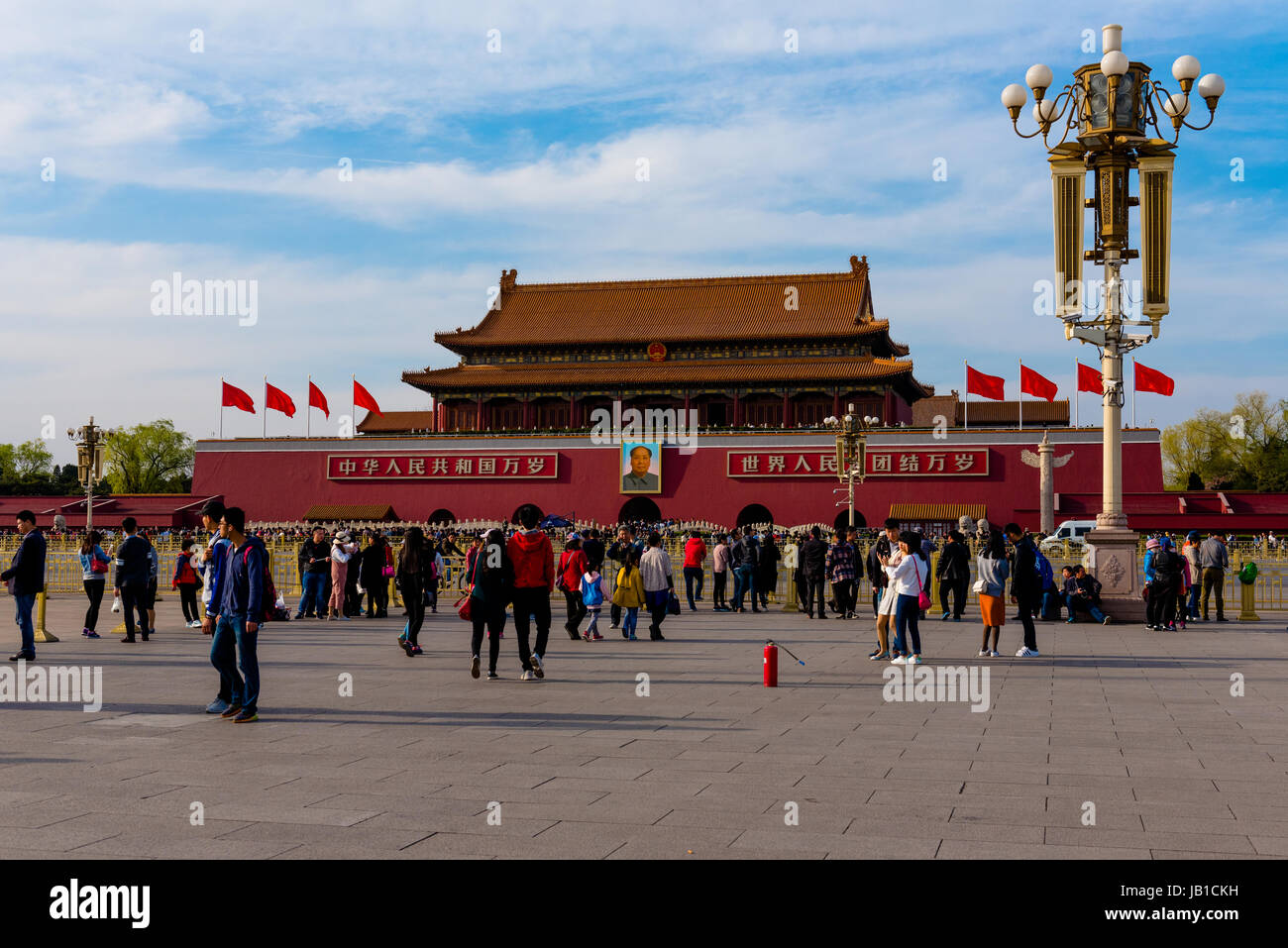 Touristen flanieren dem Tiananmen-Platz, wo ein Porträt von Mao prominent angezeigt wird Stockfoto