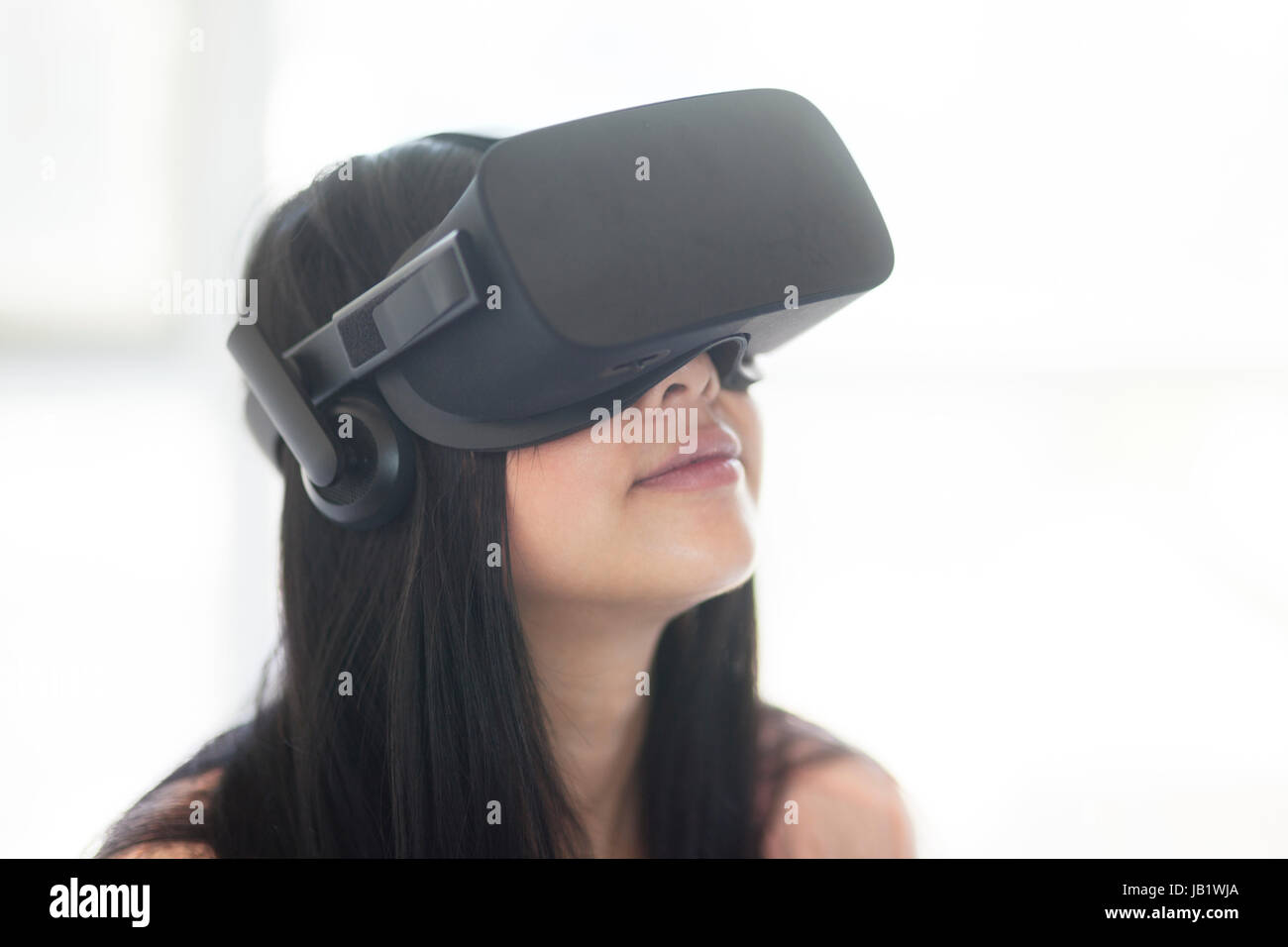 Junge asiatische Frau mit Virtual Reality headset Oculus Rift und demonstrieren, wie der Touch Control zu verwenden Stockfoto