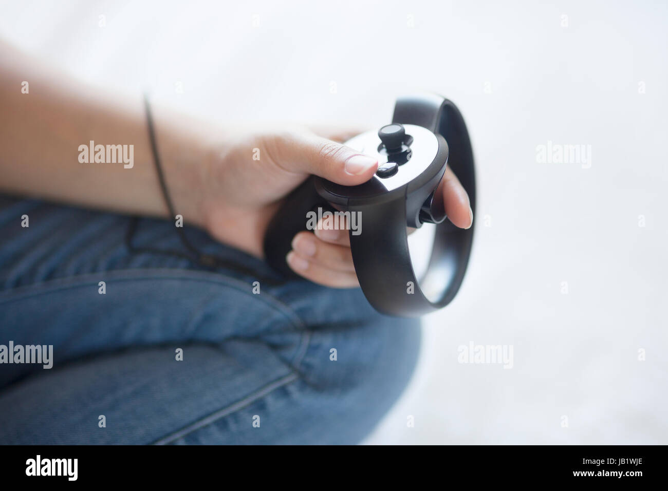 Junge asiatische Frau mit Virtual Reality headset Oculus Rift und demonstrieren, wie der Touch Control zu verwenden Stockfoto