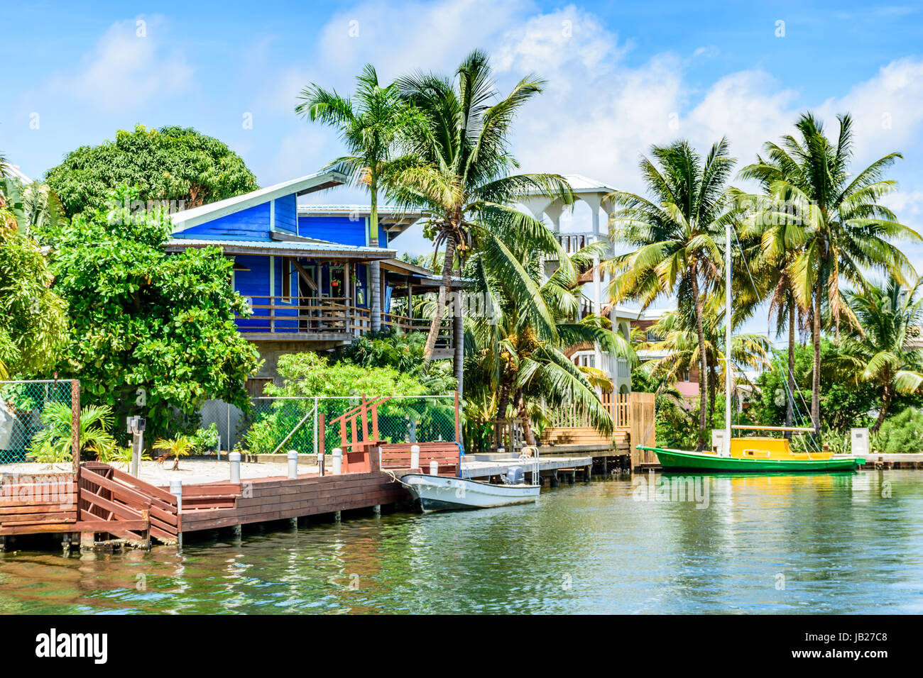 Placencia, Belize - 28. August 2016: Tropenhaus am Ufer festgemachten Boote auf der Lagunenseite von Placencia in Belize, Mittelamerika Stockfoto