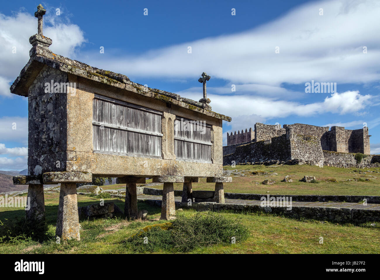 Ein altes Kornhaus (Spalieren) und die Burg über dem Dorf Lindoso im Parque Nacional da Peneda-Geres in Nordportugal. Stockfoto