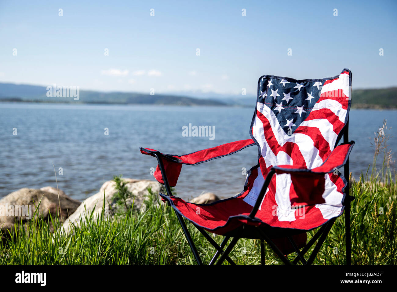 American flag Campingstuhl am See für 4. Juli Feier Stockfoto