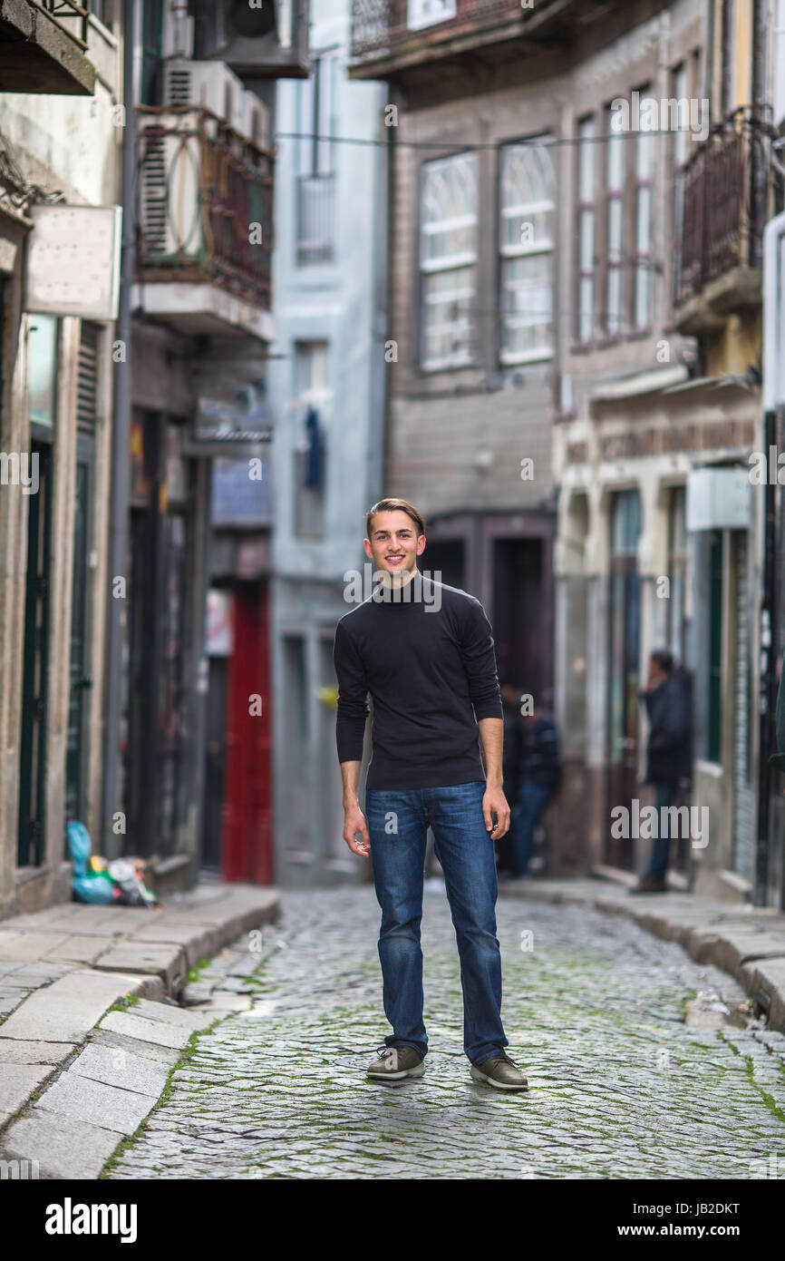 Ein hübscher junger Kerl steht in einer der engen Gassen der Altstadt. Stockfoto