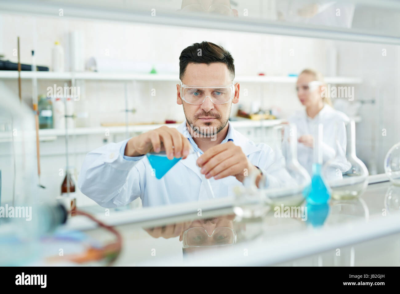 Moderne Wissenschaftler arbeiten im Labor mit Reagenzgläsern und reagieren Stockfoto