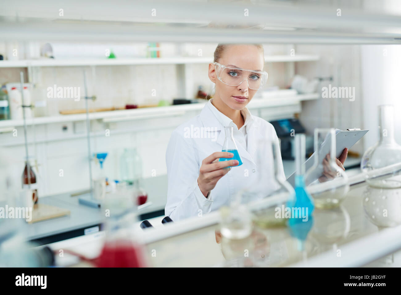 Schöne Frau mit Reagenzglas im Labor Stockfoto