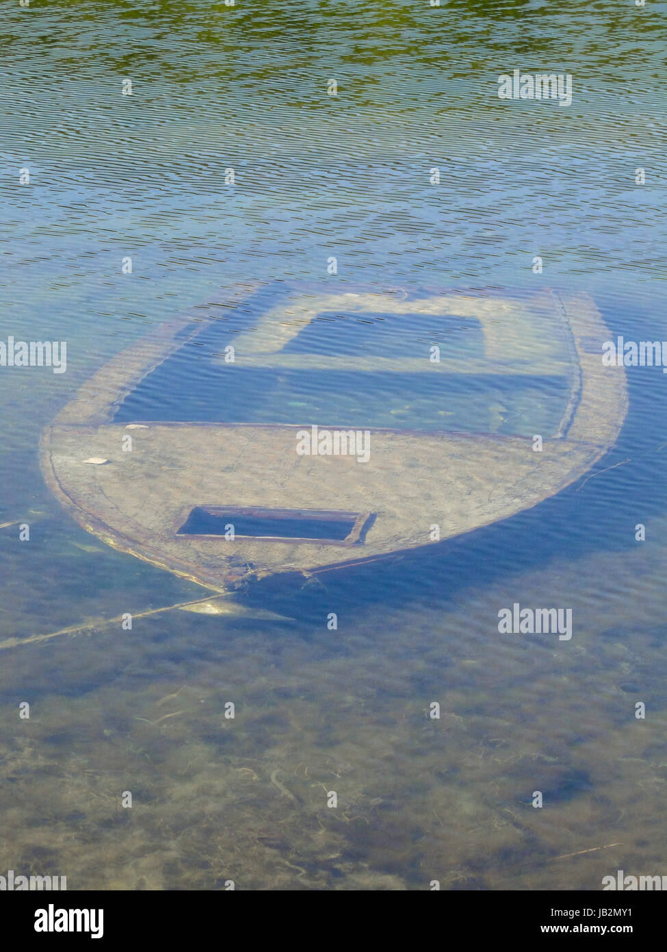 kleines Fischerboot liegt auf dem Boden eines flachen Sees. Stockfoto