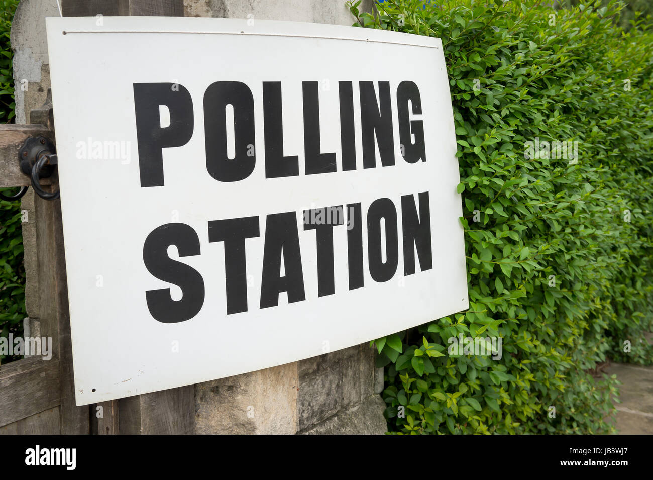 Wahlen in Großbritannien Wahllokal Schild hängen auf Pfosten neben einer Hecke im Vereinigten Königreich Stockfoto