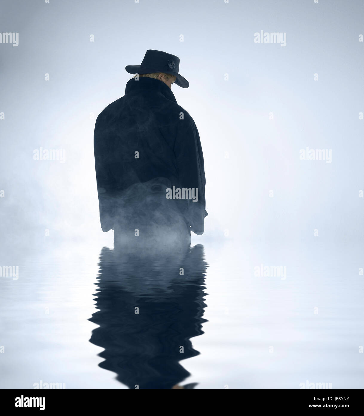 mystische Landschaft zeigt eine Person trug einen dunklen Mantel und Hütte stehend im nebligen Ambiente mit reflektierenden Wasseroberfläche Stockfoto